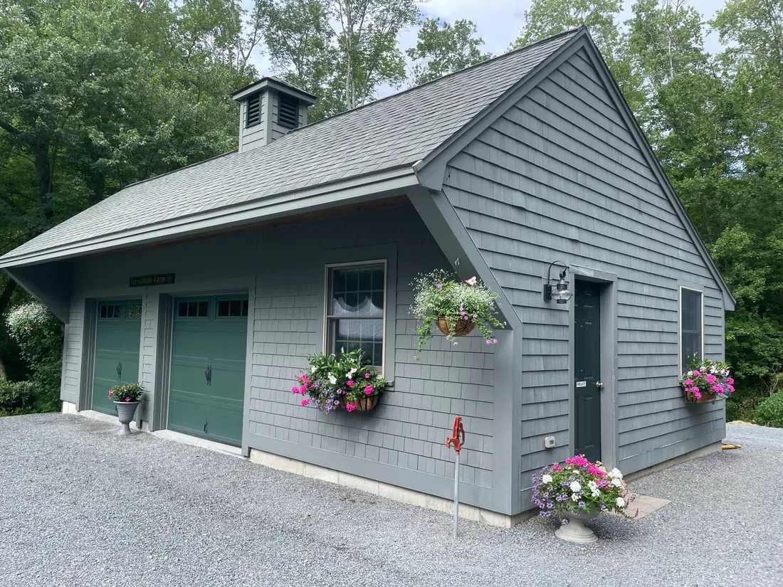 The gray barn at Terrydiddle Farm with window boxes of flowers
