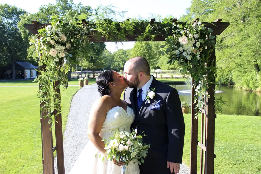 Couple kissing under the floral arbor
