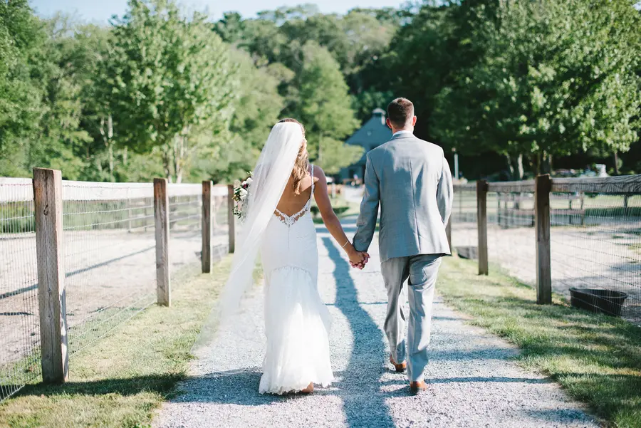Couple walking hand in hand along the fence