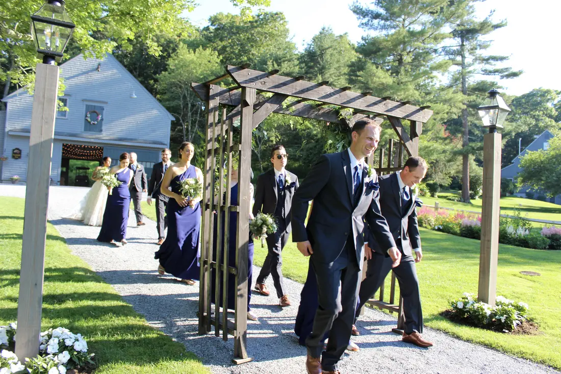 A couple walking toward the ceremony arbor